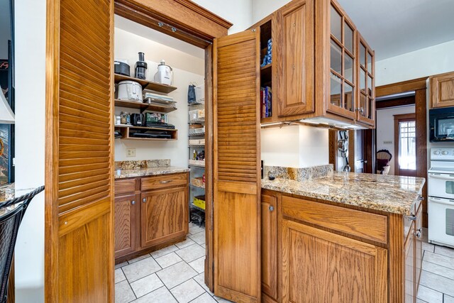 kitchen featuring light stone counters and double oven range