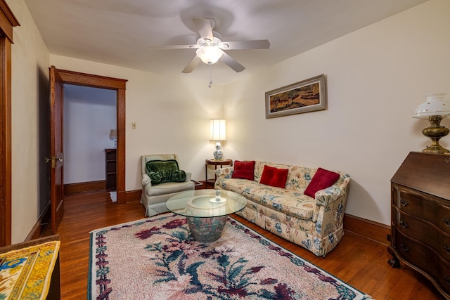 living room featuring dark wood-type flooring and ceiling fan