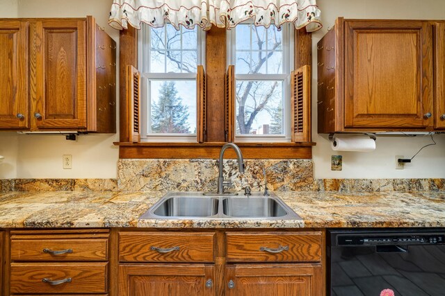 kitchen with black dishwasher, sink, and light stone countertops