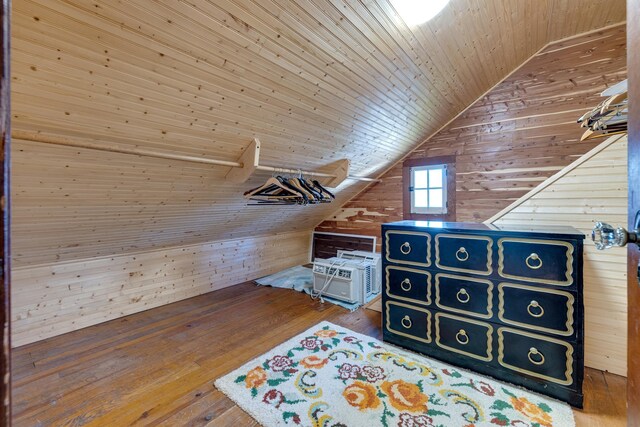 bonus room featuring hardwood / wood-style flooring, cooling unit, wooden walls, vaulted ceiling, and wooden ceiling