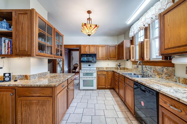 kitchen with decorative light fixtures, sink, light stone counters, and black appliances