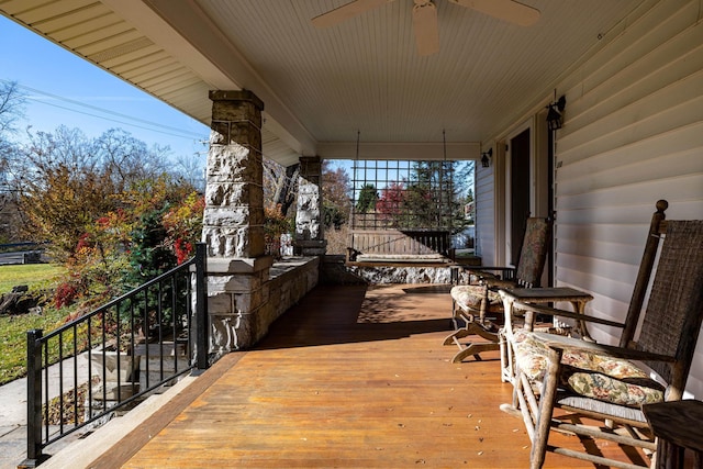 wooden terrace with ceiling fan and covered porch