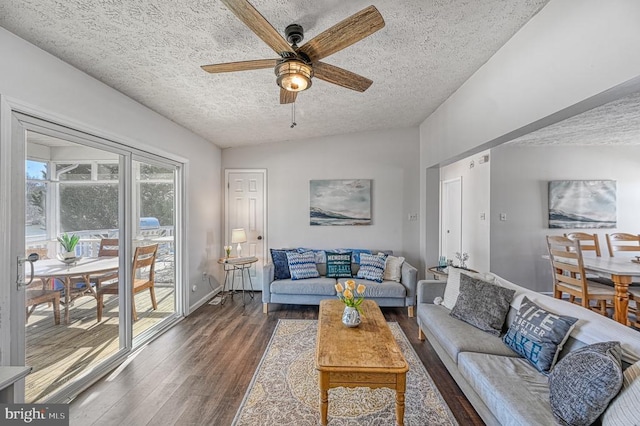 living area with a textured ceiling, wood finished floors, a ceiling fan, and baseboards