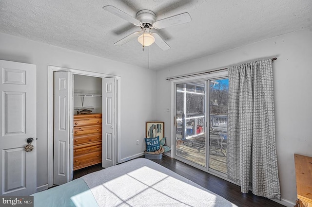 unfurnished bedroom with baseboards, dark wood-style floors, access to exterior, a textured ceiling, and a closet