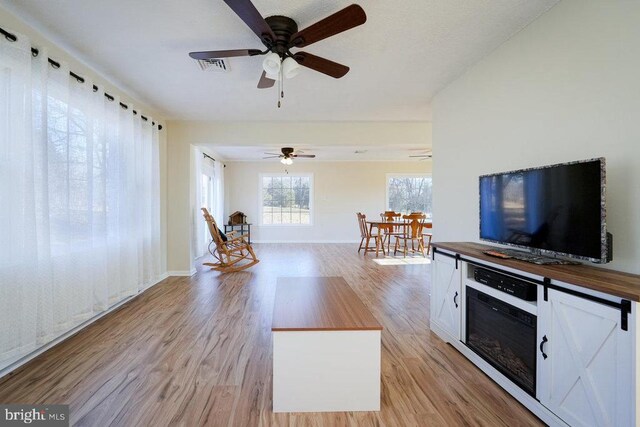 unfurnished living room featuring ceiling fan and light hardwood / wood-style flooring