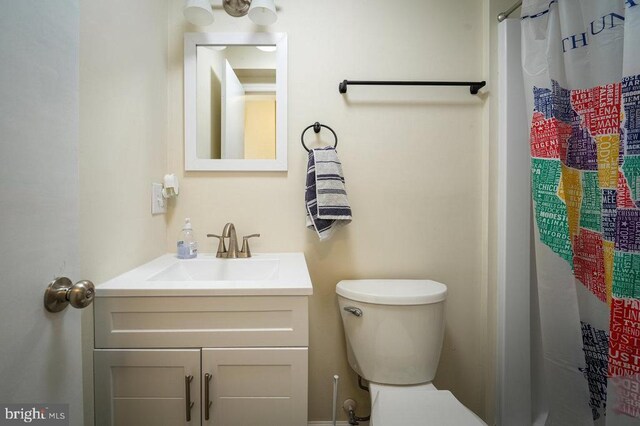 bathroom with vanity, curtained shower, and toilet