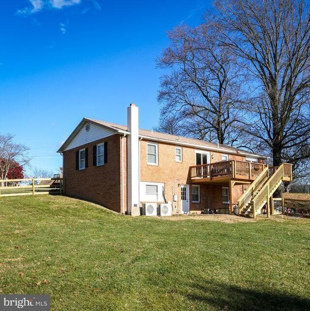 back of house with a wooden deck, a lawn, and ac unit