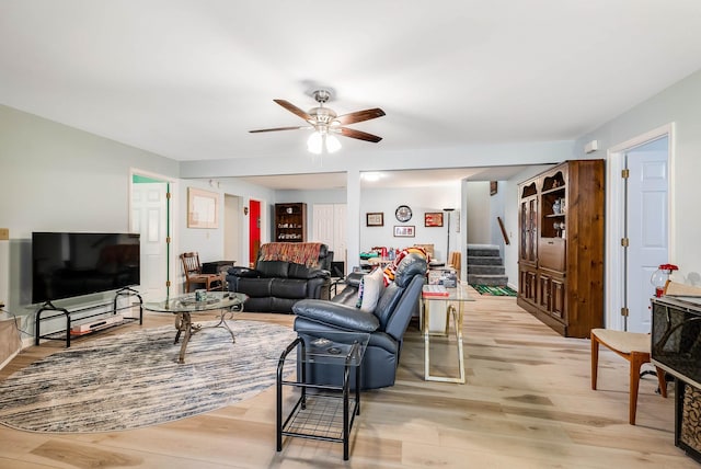 living room featuring light hardwood / wood-style flooring and ceiling fan