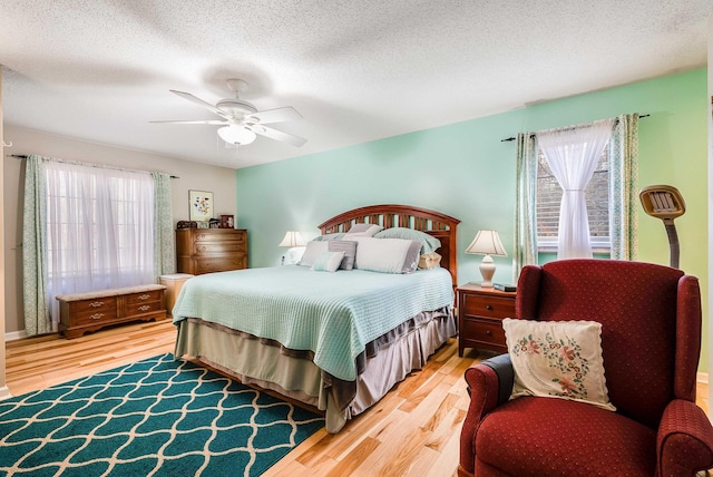 bedroom featuring multiple windows, wood-type flooring, and ceiling fan