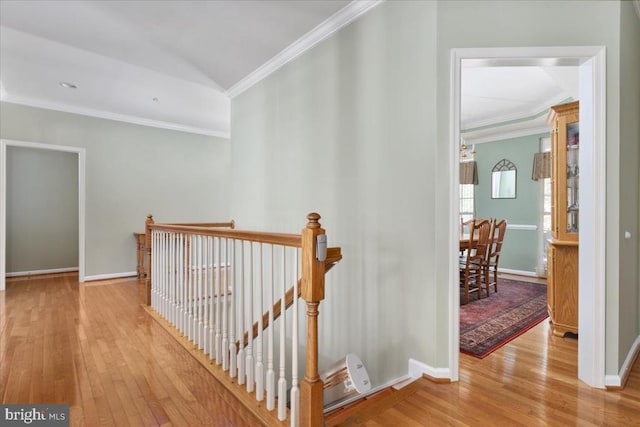 hallway with crown molding, baseboards, an upstairs landing, and hardwood / wood-style flooring