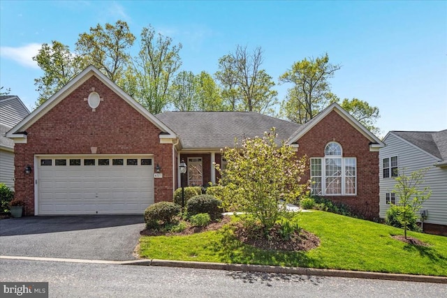 ranch-style home with brick siding, a garage, a front lawn, and aphalt driveway