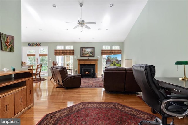 living area featuring high vaulted ceiling, ceiling fan, and light wood finished floors