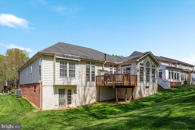 rear view of house with a lawn, cooling unit, a deck, and brick siding