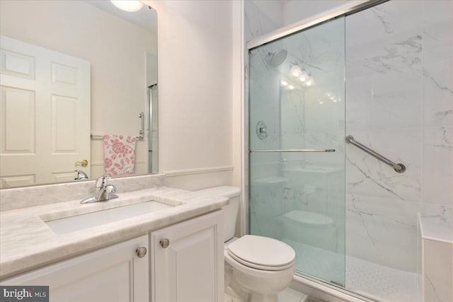 full bathroom featuring toilet, a marble finish shower, and vanity