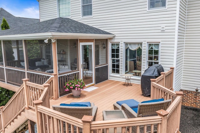 deck with a sunroom, area for grilling, and stairs