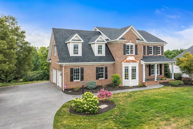 view of front of property with brick siding, a shingled roof, concrete driveway, a front yard, and a garage