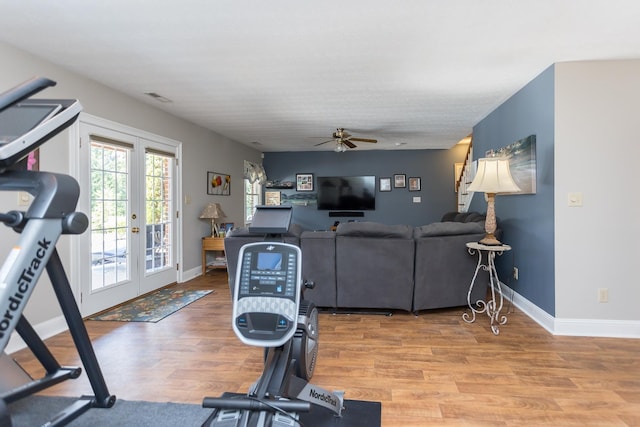 workout area with visible vents, french doors, light wood-style flooring, and baseboards