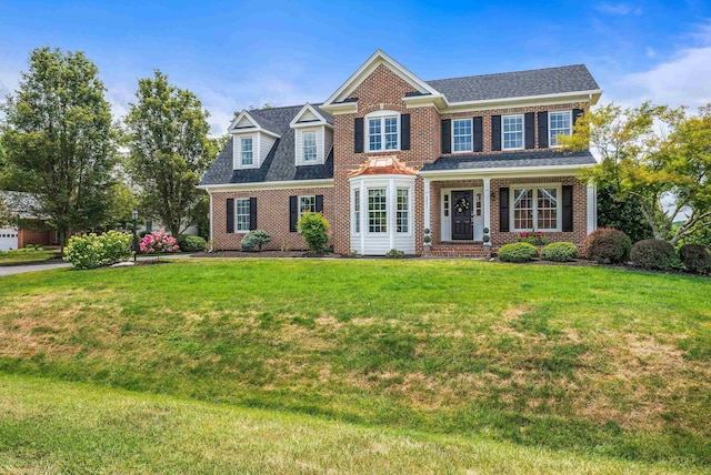 view of front of property with roof with shingles, brick siding, and a front lawn