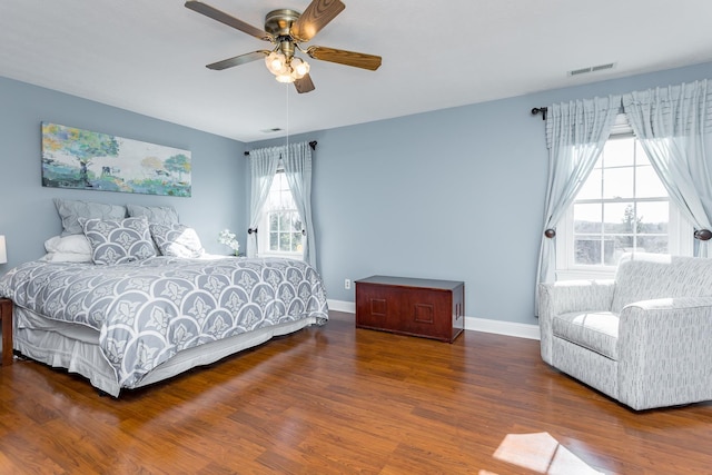 bedroom with visible vents, ceiling fan, baseboards, and wood finished floors