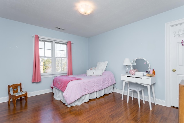 bedroom featuring baseboards, visible vents, and wood finished floors