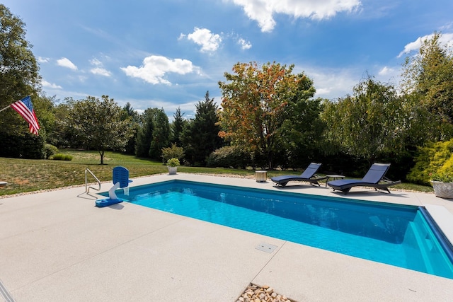 outdoor pool featuring a lawn and a patio area