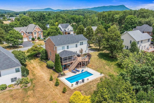 drone / aerial view featuring a mountain view and a view of trees