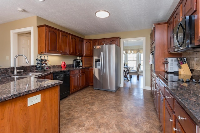 kitchen with a sink, black appliances, dark stone counters, a peninsula, and baseboards