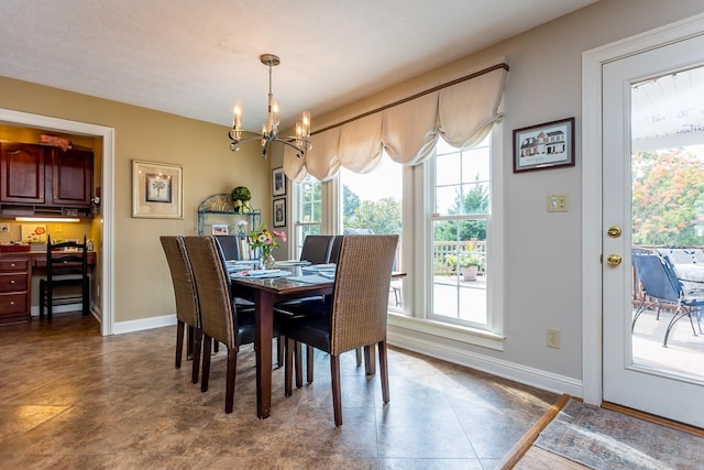 dining space featuring an inviting chandelier and baseboards