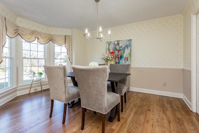 dining space with a wealth of natural light, wood finished floors, a chandelier, baseboards, and wallpapered walls