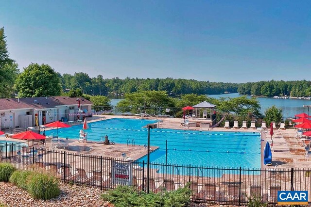 view of swimming pool featuring a patio and a water view