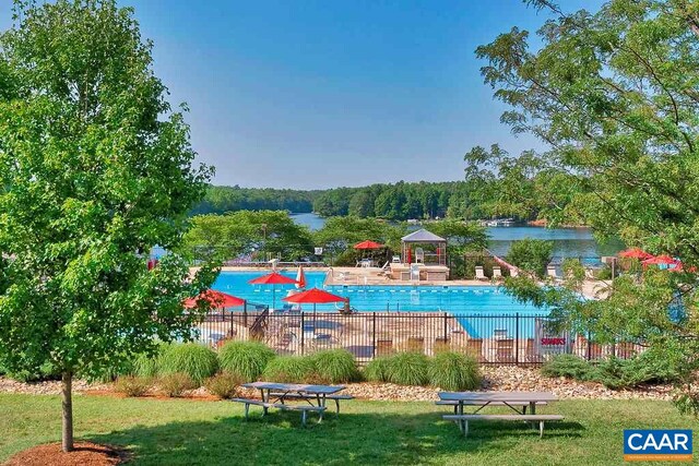 view of pool featuring a yard and a water view