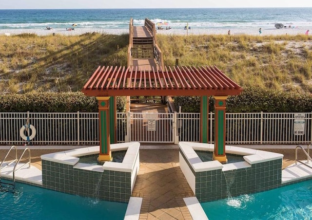 view of pool featuring a patio area, pool water feature, and a water view