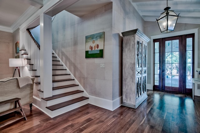 entrance foyer with crown molding, dark hardwood / wood-style flooring, tile walls, a chandelier, and lofted ceiling