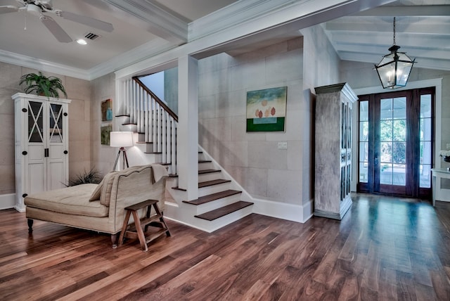 foyer entrance with ceiling fan with notable chandelier, dark hardwood / wood-style floors, and ornamental molding