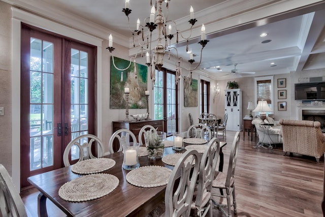 dining space with french doors, ceiling fan with notable chandelier, coffered ceiling, beamed ceiling, and hardwood / wood-style floors