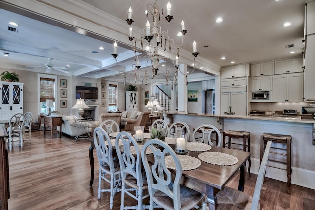 dining space featuring wood-type flooring, ceiling fan, crown molding, and beamed ceiling