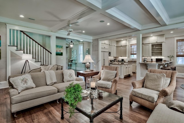 living room with beamed ceiling, hardwood / wood-style floors, ornamental molding, coffered ceiling, and ceiling fan