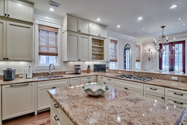 kitchen with light hardwood / wood-style floors, stainless steel gas cooktop, sink, and light stone countertops