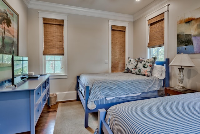 bedroom featuring ornamental molding and dark hardwood / wood-style flooring