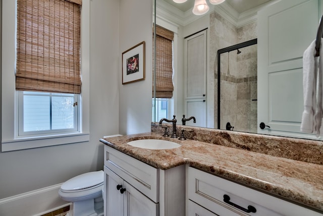 bathroom featuring vanity with extensive cabinet space, toilet, and crown molding