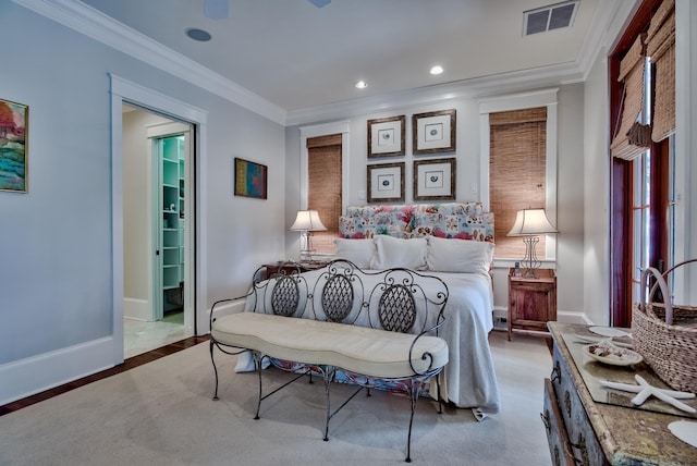 carpeted bedroom with ceiling fan and ornamental molding