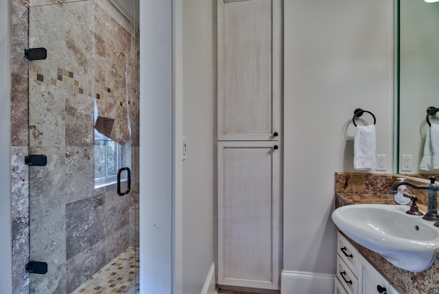 bathroom featuring a shower with door and vanity