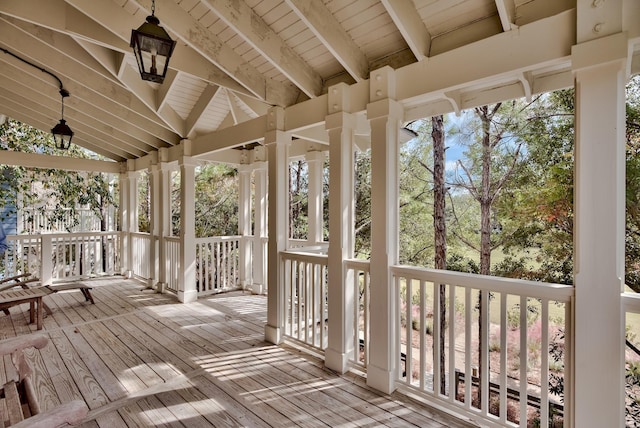 unfurnished sunroom with wood ceiling, a healthy amount of sunlight, and vaulted ceiling with beams