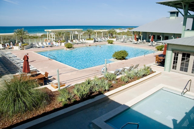 view of pool featuring a patio area and a water view