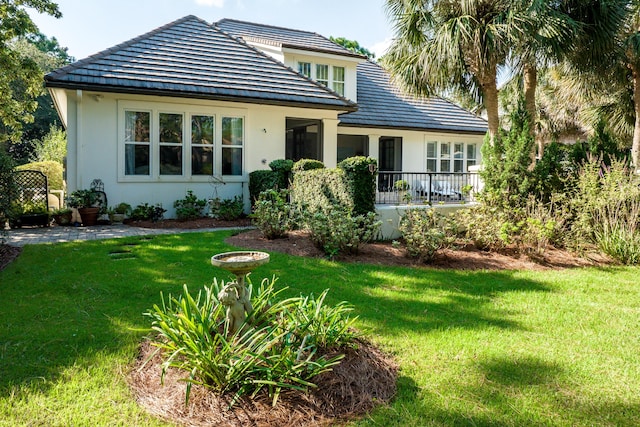 view of front of house featuring stucco siding and a front lawn