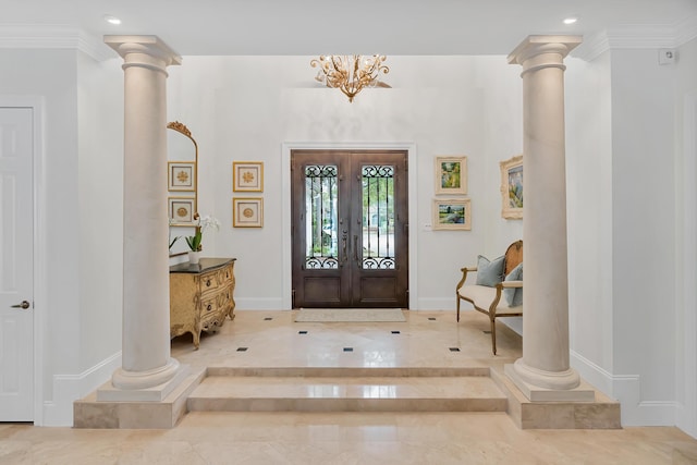 foyer entrance featuring baseboards and ornate columns