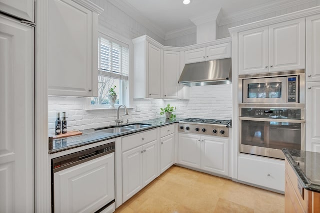 kitchen with dark stone counters, ornamental molding, a sink, appliances with stainless steel finishes, and under cabinet range hood