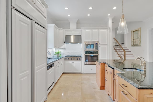 kitchen with under cabinet range hood, backsplash, appliances with stainless steel finishes, and a sink