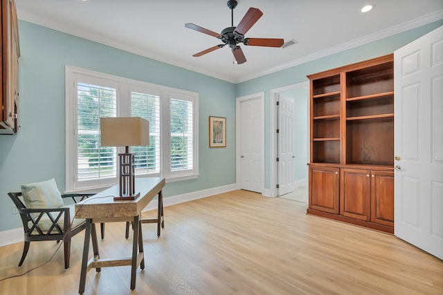 office area with light wood-type flooring, visible vents, ornamental molding, a ceiling fan, and baseboards