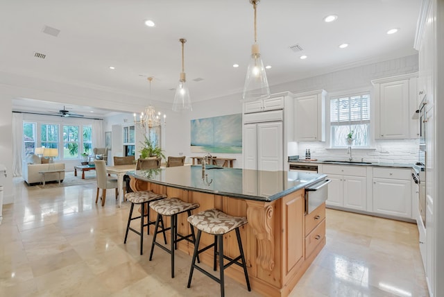 kitchen featuring visible vents, a kitchen island, open floor plan, a warming drawer, and a sink